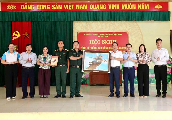 Thường trực Đảng ủy xã Sóc Sơn tặng bức tranh cảm ơn sự sẻ chia, giúp đỡ của cán bộ, chiến sĩ Tiểu đoàn Trinh sát (Bộ Tư lệnh Thủ đô Hà Nội). Ảnh: CTV.