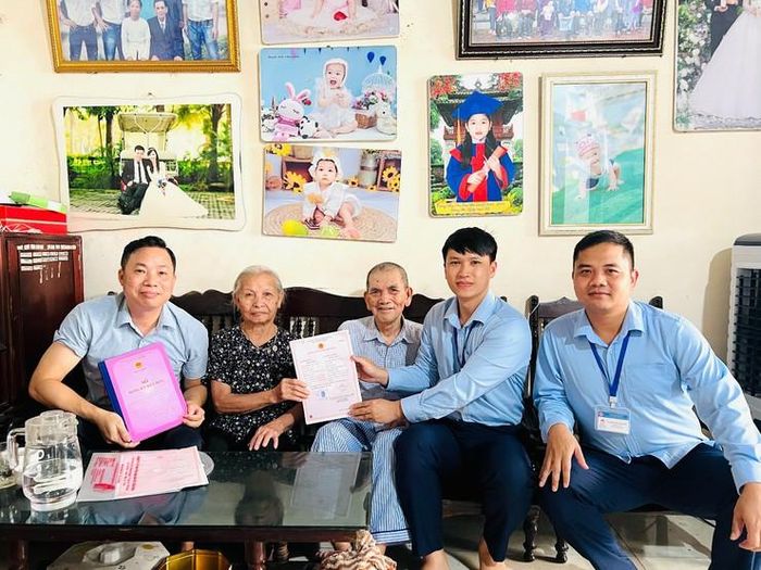 Vợ chồng cụ Dương Văn Lợi vui mừng được Tổ xung kích Điểm hỗ trợ dịch vụ công số Kiều Phú trao Giấy chứng nhận kết hôn ngay tại nhà. Ảnh: Thúy Quỳnh