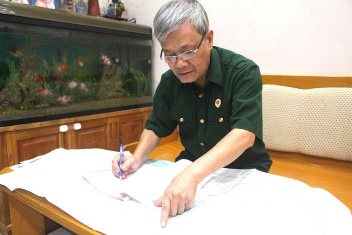 Đại tá, cựu chiến binh Trần Tường Huấn gắn bó với tấm bản đồ trên hành trình đi tìm đồng đội. Ảnh: Vi Giáng