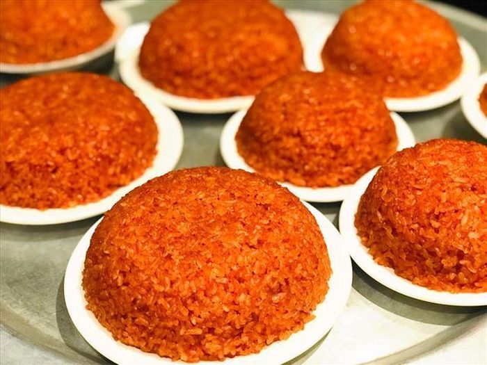 Xôi gấc nóng hổi, dẻo thơm mùi nếp và gấc trộn lẫn với nhau.