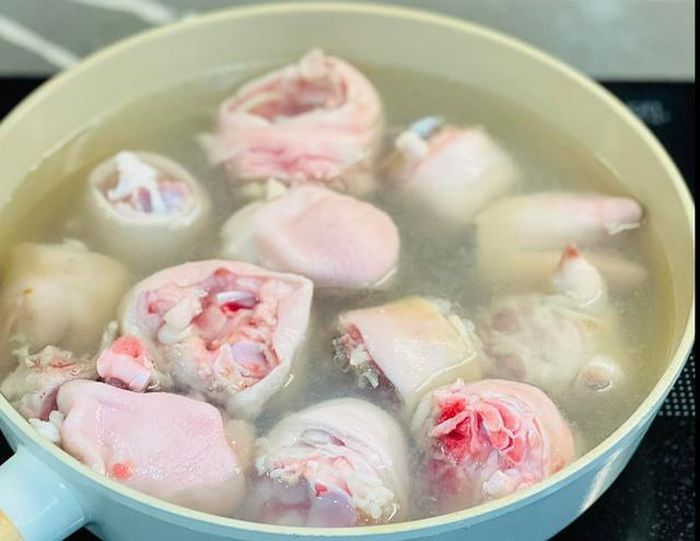 Chân giò làm sạch, rửa nước muối loãng rồi đem chần qua nước sôi có cho thêm vài lát gừng, muối và hành tím khoảng 5 phút để loại tạp chất và mùi hôi. 