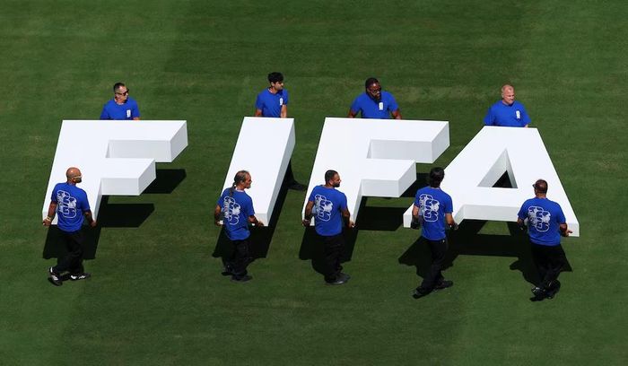 Nhân viên sân cỏ mang logo FIFA trên sân trước trận đấu. Nguồn: Reuters.