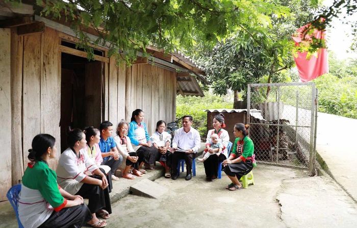 Cán bộ xã phối hợp với trưởng bản tuyên truyền cho người dân bản Nậm Sảo 1 về xóa bỏ những hủ tục lạc hậu. Ảnh: TTXVN