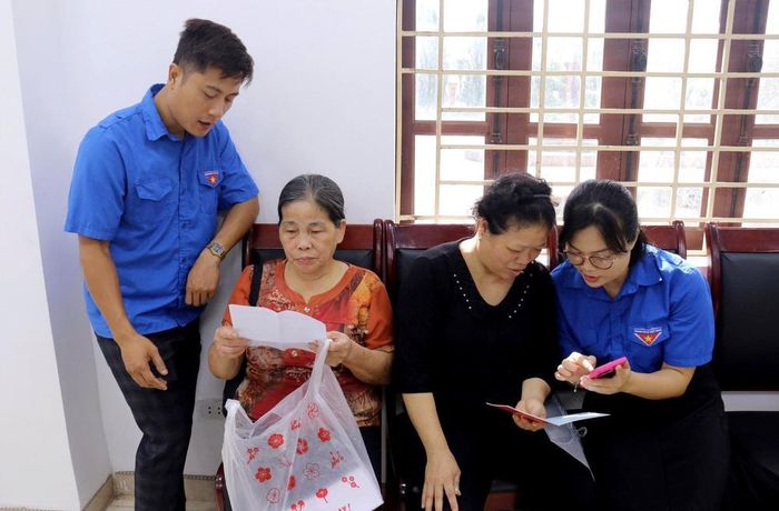 Lực lượng đoàn viên thanh niên phường Phố Hiến (Hưng Yên) hỗ trợ, hướng dẫn người dân thực hiện các thủ tục tại bộ phận “một cửa”. Ảnh: TTXVN