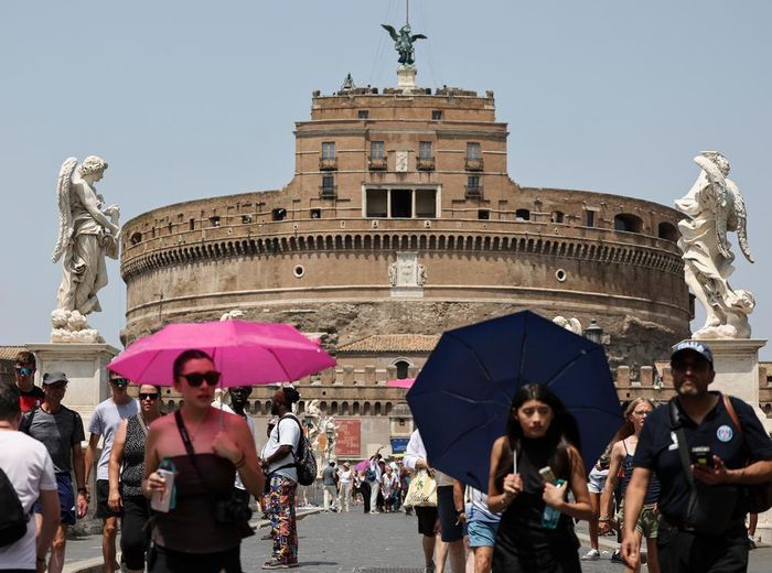 Khách du lịch che ô để tránh nắng nóng tại Rome, Italy. Ảnh: THX/TTXVN phát