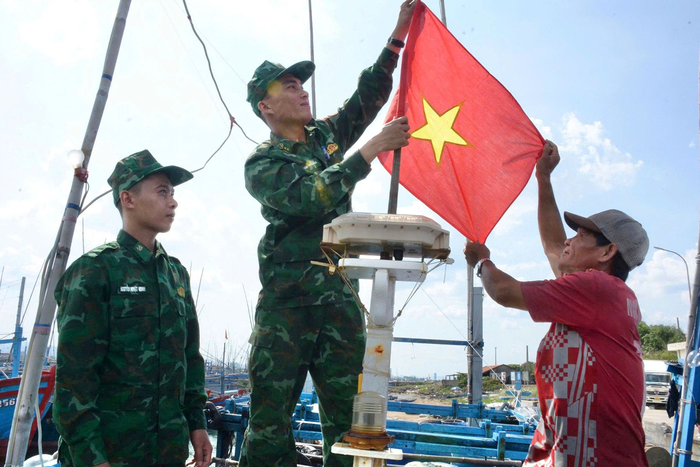 Bộ đội tặng cờ Tổ quốc cho các chủ tàu, thuyền.