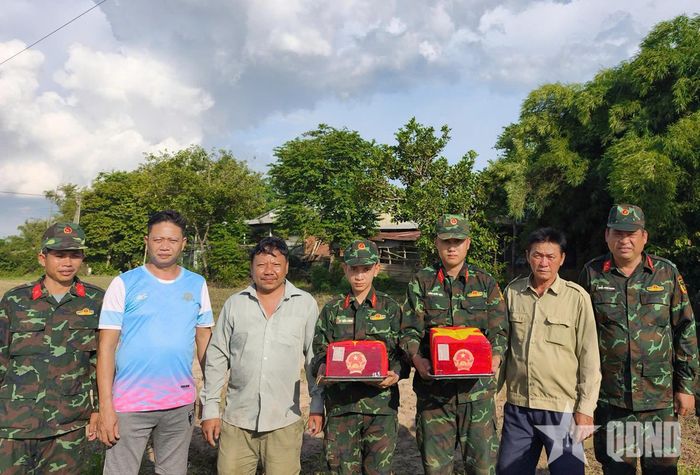 Cán bộ, chiến sĩ Đội K71 phối hợp với lực lượng địa phương thành kính bên hài cốt liệt sĩ.