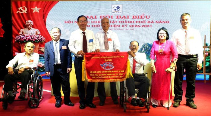 Phó Chủ tịch thường trực Liên hiệp Hội về NKT Việt Nam Đặng Văn Thanh (thứ 3 từ trái sang) trao tặng Cờ thi đua cho Hội NKT TP Đà Nẵng.