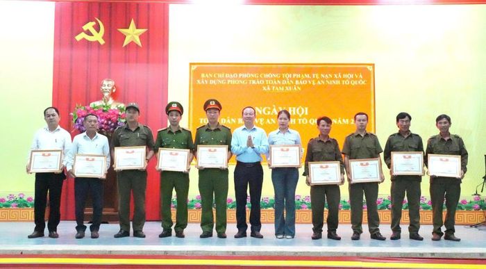 Lãnh đạo xã Tam Xuân tặng Giấy khen cho 5 tập thể, 10 cá nhân đạt thành tích xuất sắc trong phong trào Toàn dân BVANTQ năm 2026.Ảnh: Ái Ly.