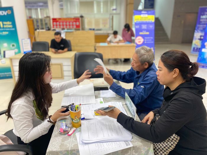  Nhân viên ngân hàng hỗ trợ hộ kinh doanh thực hiện kê khai doanh thu và thông báo tài khoản ngân hàng tại Cơ sở 3 Thuế TP Đồng Nai. Ảnh: PHÚ NGÂN 