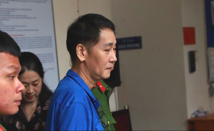  Bị cáo Nguyễn Lê Minh được dẫn giải sau phiên xét xử. Ảnh: SONG MAI 