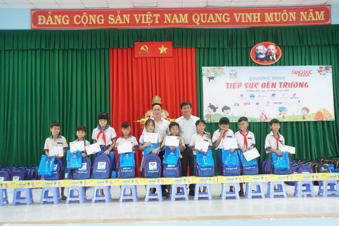 Nhà báo Nguyễn Anh Tú, Phó Trưởng phụ trách Cơ quan thường trú Báo Giáo dục và Thời đại tại TPHCM (trái) cùng ông Trịnh Văn Luận, Bí thư Đảng ủy - Chủ tịch HĐND xã Tà Lài trao học bổng cho học sinh.