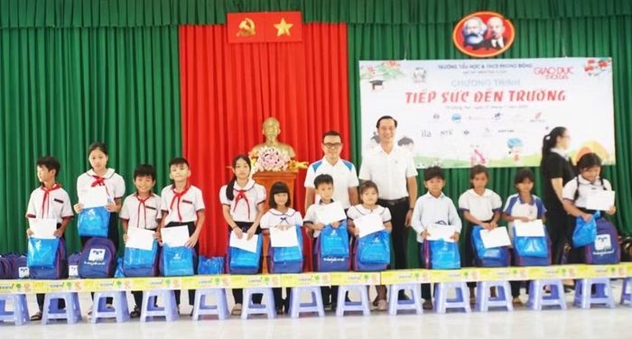 Ông Nguyễn Đắc Lực, Phó Tổng Giám đốc của Công ty Cổ phần Xuất Nhập khẩu Bình Tây (BITEX) và ông Nguyễn Anh Tuấn - Phó Trưởng Phòng Văn hóa - Xã hội (xã Tà Lài) trao học bổng cho học sinh.