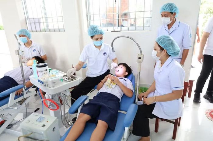 Nhân viên y tế thăm khám nha cho học sinh.