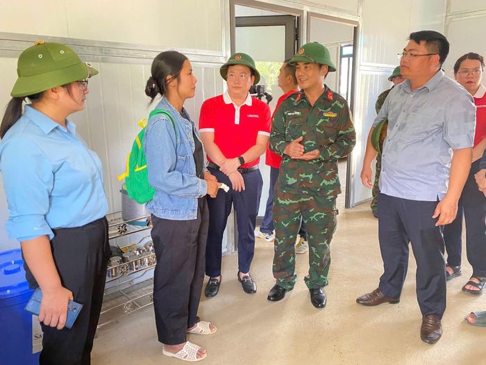 Đại diện chính quyền địa phương và đơn vị thi công làm thủ tục bàn giao nhà cho người dân