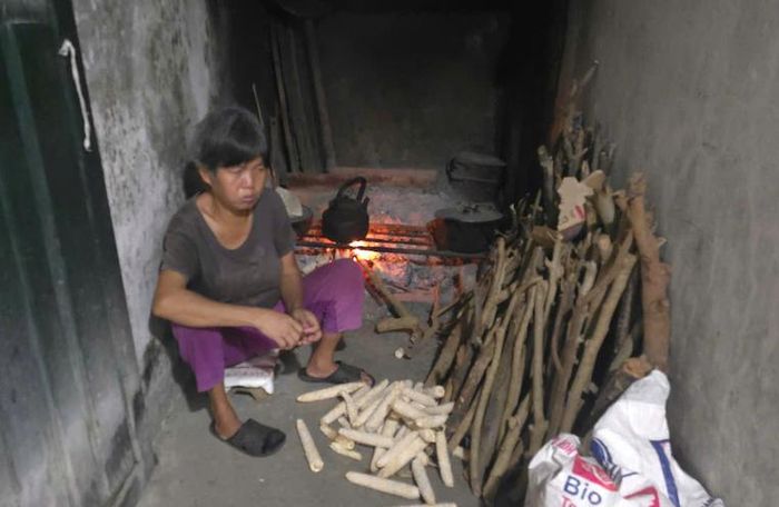 Bà Thanh bị thiểu năng vẫn nhóm lửa, nấu cơm vì sợ em gái có thể lên cơn động kinh bất chợt. Ảnh: Đức Tuấn