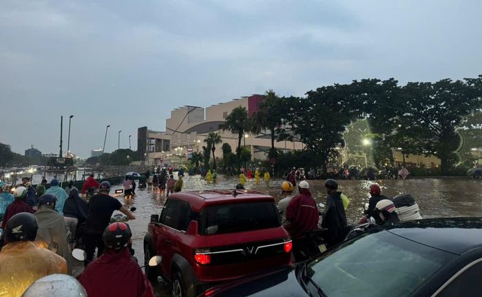 Người dân dắt xe qua đoạn đường ngập sâu. Ảnh: LD.