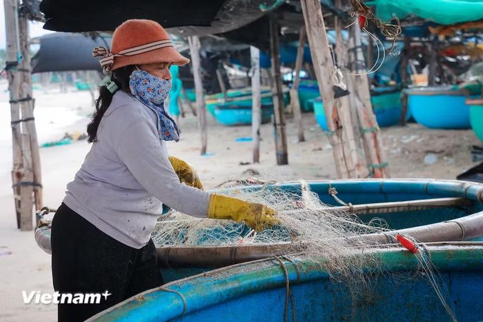 Ngư dân sau mỗi chuyến thu hoạch lại tất tưởi sửa soạn những tấm lưới chuẩn bị cho những buổi ra khơi tiếp theo. (Ảnh: Hoài Nam/Vietnam+)