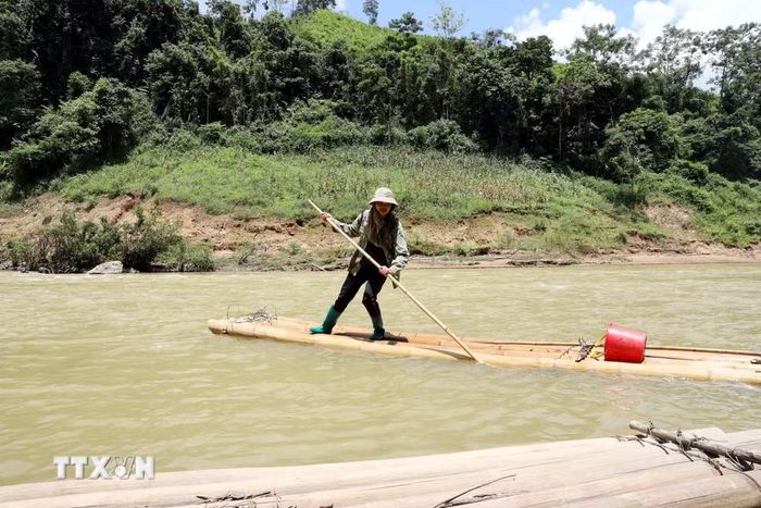 Người Dao ở xóm Song Phụ, thôn Khuổi Luông, xã Quý Hòa (Lạng Sơn) vượt qua sông Bắc Giang bằng bè mảng ghép tạm từ những cây luồng. (Ảnh: Văn Đạt/TTXVN)