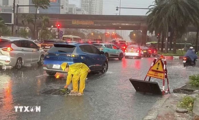 Công nhân Công ty TNHH MTV Thoát nước Hà Nội khẩn trương ứng trực kịp thời tiêu thoát nước khi ngập úng. (Ảnh: Nguyễn Thắng/TTXVN)