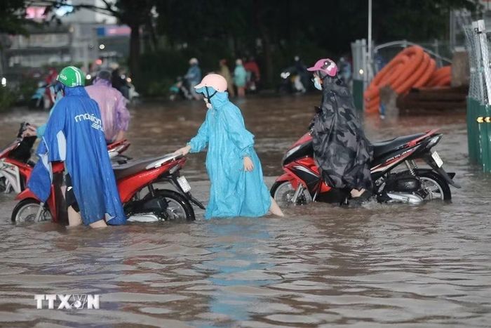 Ngập cục bộ trên phố Đàm Quang Trung sau cơn mưa lớn tại Hà Nội. (Ảnh: Thành Phương/TTXVN)