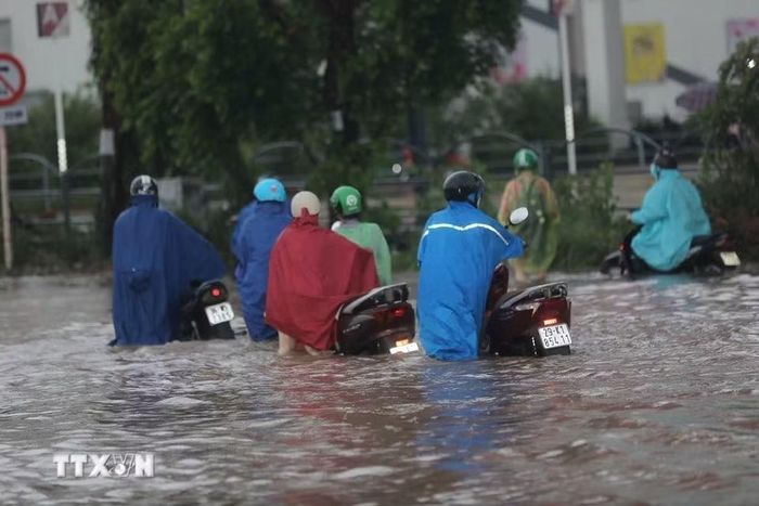 Ngập cục bộ trên phố Đàm Quang Trung sau cơn mưa lớn tại Hà Nội. (Ảnh: Thành Phương/TTXVN)