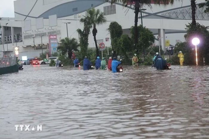 Ngập cục bộ trên phố Đàm Quang Trung sau cơn mưa lớn tại Hà Nội. (Ảnh: Thành Phương/TTXVN)