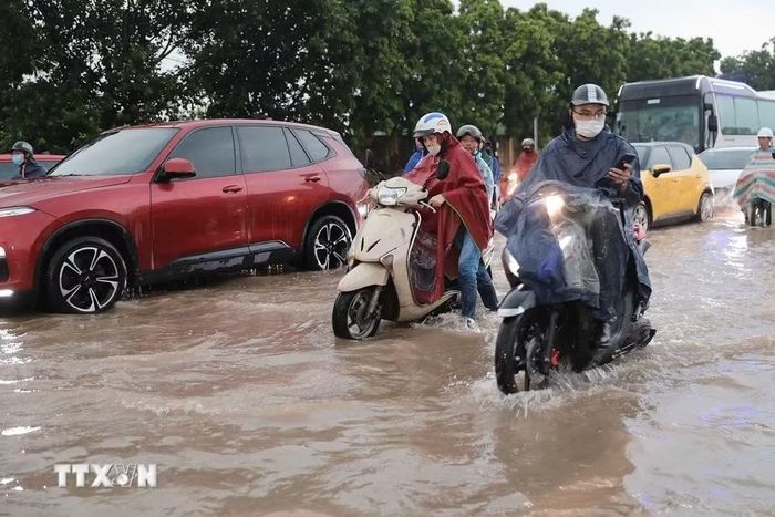 Ngập cục bộ trên phố Đàm Quang Trung sau cơn mưa lớn tại Hà Nội. (Ảnh: Thành Phương/TTXVN)