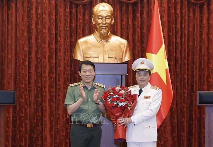 Đại tướng Lương Tam Quang, Ủy viên Bộ Chính trị, Bí thư Đảng ủy Công an Trung ương, Bộ trưởng Bộ Công an tặng hoa chúc mừng Thượng tướng Đặng Hồng Đức. Ảnh: Thống Nhất/TTXVN