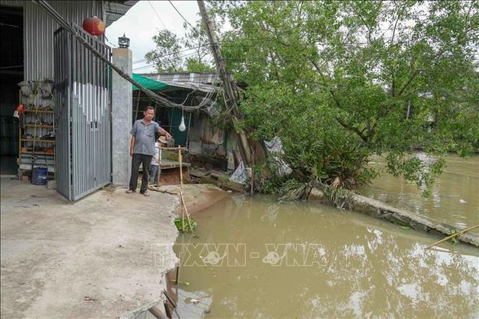 Tuyến đường bê tông qua khu vực đông dân cư ở gần bến phà Mang Cá (xã Đại Hải) bị chia cắt hoàn toàn do sạt lở. Ảnh: Thanh Liêm/TTXVN