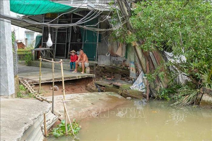Tuyến đường bê tông qua khu vực đông dân cư ở gần bến phà Mang Cá (xã Đại Hải) bị chia cắt hoàn toàn do sạt lở. Ảnh: Thanh Liêm/TTXVN