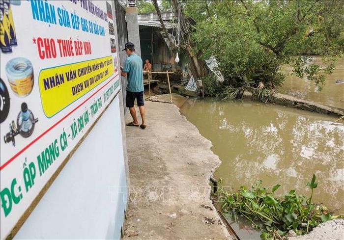 Tuyến đường bê tông qua khu vực đông dân cư ở gần bến phà Mang Cá (xã Đại Hải) bị chia cắt hoàn toàn do sạt lở. Ảnh: Thanh Liêm/TTXVN