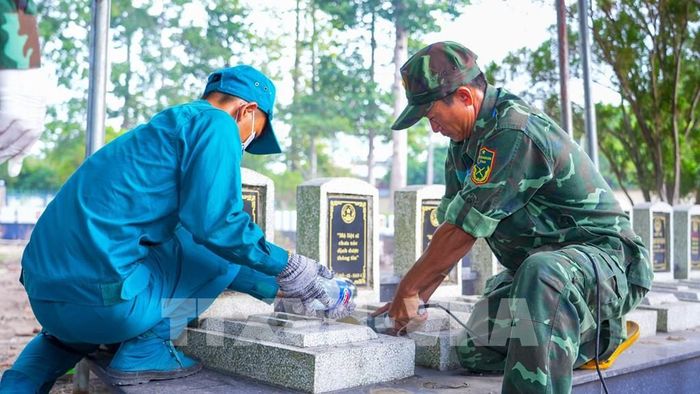 Các lực lượng thực hiện công tác lấy mẫu hài cốt liệt sĩ chưa xác định được thông tin tại Nghĩa trang Liệt sĩ Dương Minh Châu. Ảnh: Minh Phú - TTXVN