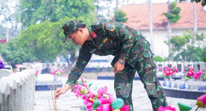 Thắp hương tưởng niệm các Anh hùng liệt sĩ tại Nghĩa trang Liệt sĩ Dương Minh Châu. Ảnh: Minh Phú - TTXVN