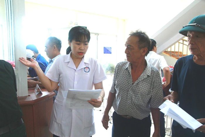 Bà Lê Thị Tú, viên chức của trạm y tế xã Thiên Lộc đang hướng dẫn người dân.