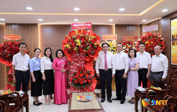 Phó Bí thư Thường trực Thành ủy Nguyễn Khắc Toàn (thứ 5, từ phải sang) trao lẵng hoa chúc mừng Ban Tuyên giáo và Dân vận Thành ủy. Ảnh: VINH ANH