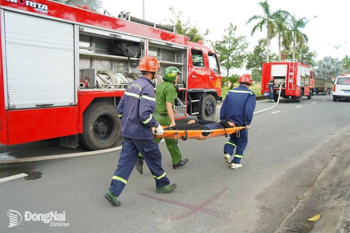 Lực lượng chức năng chuyển bệnh nhân lên xe cứu thương để đưa đến cơ sở y tế.
