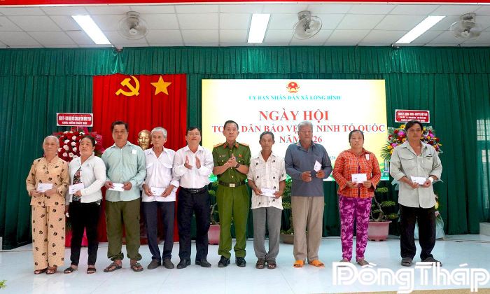 Đại tá Trần Văn Tròn và Bí thư Đảng ủy, Chủ tịch HĐND xã Võ Ngọc Tân trao quà cho các gia đình chính sách.