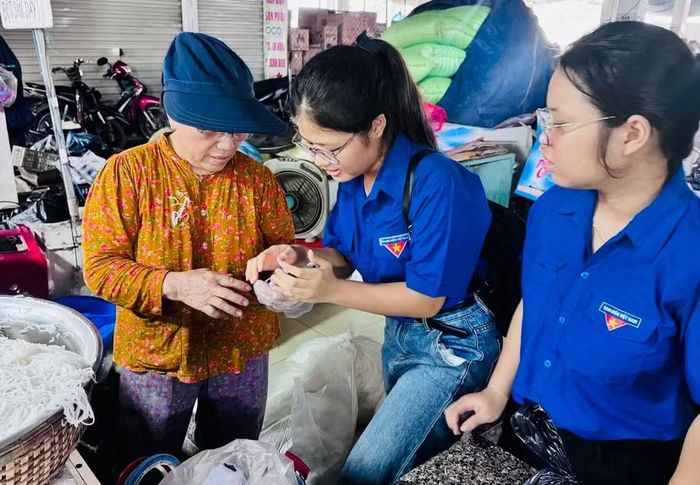 Tại các chợ, thành viên Tổ Công nghệ số cộng đồng đã trực tiếp đến từng quầy hàng, lô, sạp để hướng dẫn tiểu thương và người dân cách kết nối, sử dụng mạng Wifi công cộng miễn phí trên điện thoại thông minh. Ảnh: Đ.Y