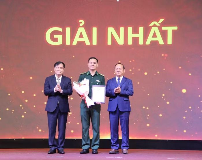 Đồng chí Phan Xuân Thủy - Phó Trưởng ban Tuyên giáo và Dân vận Trung ương (bên trái) và đồng chí Rah Lan Chung - Phó Bí thư Thường trực Tỉnh ủy, Chủ tịch HĐND tỉnh (bên phải) trao chứng nhận và tặng hoa chúc mừng thí sinh Vũ Lý Huỳnh - Bí thư Đảng ủy, Chính trị viên Đồn Biên phòng Cửa khẩu cảng Vũng Rô, Ban Chỉ huy Bộ đội Biên phòng tỉnh Đắk Lắk đạt giải nhất hội thi. Ảnh: Trọng Lợi