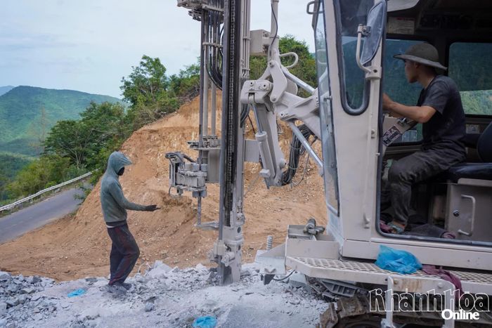 Công nhân đang nỗ lực khoan những khối đá lớn để tạo mặt bằng.