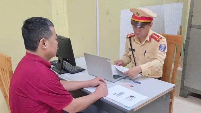 Lực lượng CSGT làm việc với người điều khiển phương tiện vi phạm.