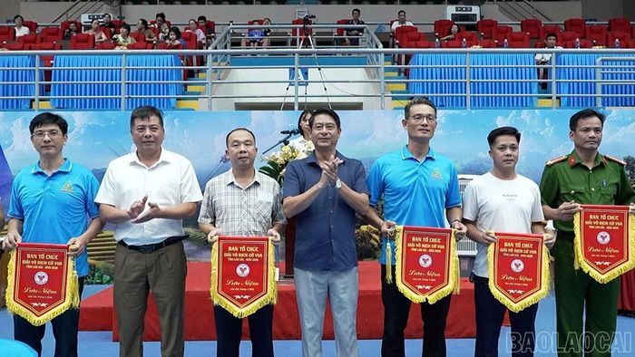 Ban tổ chức trao cờ lưu niệm cho các đơn vị tham gia giải.