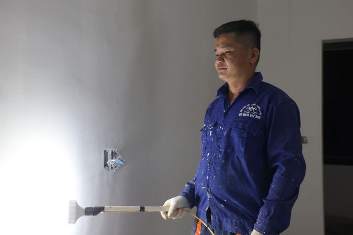 Anh Hà Bảy cùng đội sơn làm việc buổi tối tại các phòng học