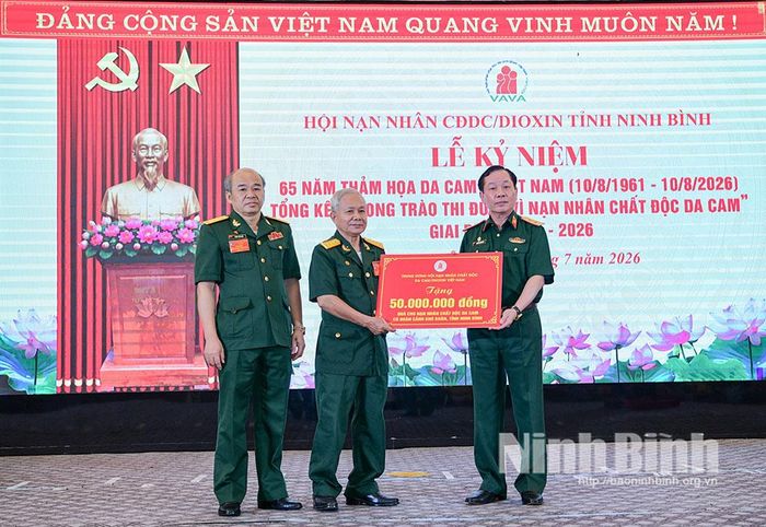 Đồng chí Trung tướng Nguyễn Hữu Chính, Chủ tịch Hội Nạn nhân chất độc da cam/Dioxin Việt Nam trao biển tượng trưng tặng quà cho nạn nhân CĐDC/Dioxin có hoàn cảnh khó khăn trên địa bàn tỉnh.