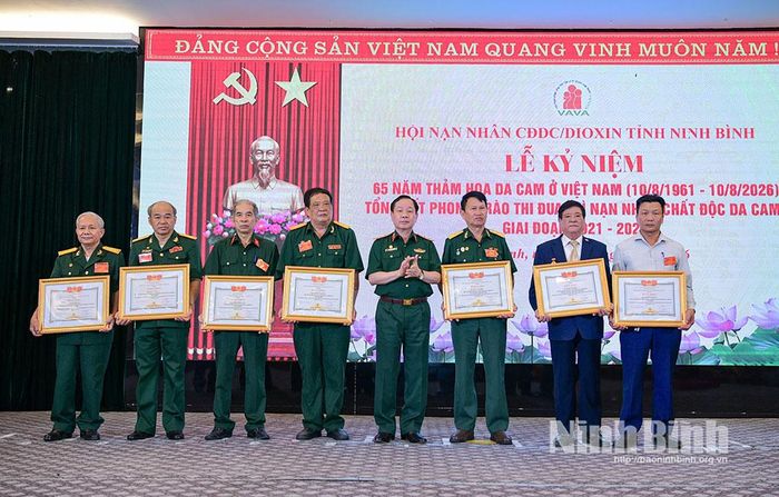 Đồng chí Trung tướng Nguyễn Hữu Chính, Chủ tịch Hội Nạn nhân chất độc da cam/Dioxin Việt Nam tặng Bằng khen của Trung ương Hội cho các cá nhân có thành tích xuất sắc trong công tác Hội.