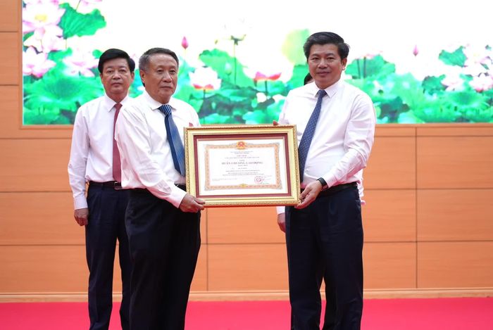 Thừa ủy quyền của Chủ tịch nước, đồng chí Trần Vũ Khiêm, Phó Bí thư Thường trực Tỉnh ủy, Trưởng đoàn đại biểu Quốc hội tỉnh trao Huân chương Lao động hạng Nhất cho đồng chí Hà Sỹ Đồng, nguyên Quyền Chủ tịch UBND tỉnh Quảng Trị (cũ) - Ảnh: T.Đ