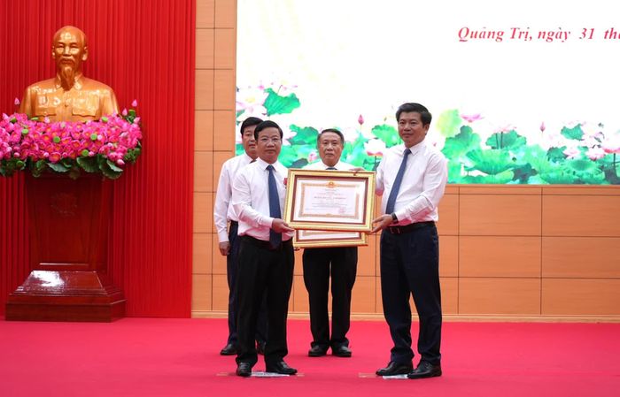 Thừa ủy quyền của Chủ tịch nước, đồng chí Trần Vũ Khiêm, Phó Bí thư Thường trực Tỉnh ủy, Trưởng đoàn đại biểu Quốc hội tỉnh trao Huân chương Lao động hạng Nhất cho đồng chí Cao Văn Định, nguyên Trưởng ban Tuyên giáo Tỉnh ủy Quảng Bình (cũ) - Ảnh: T.Đ