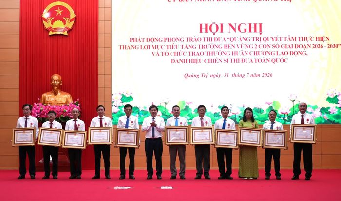 Thừa ủy quyền của Chủ tịch nước, đồng chí Trần Vũ Khiêm, Phó Bí thư Thường trực Tỉnh ủy, Trưởng đoàn đại biểu Quốc hội tỉnh trao Huân chương Lao động hạng Nhì cho các cá nhân - Ảnh: T.Đ
