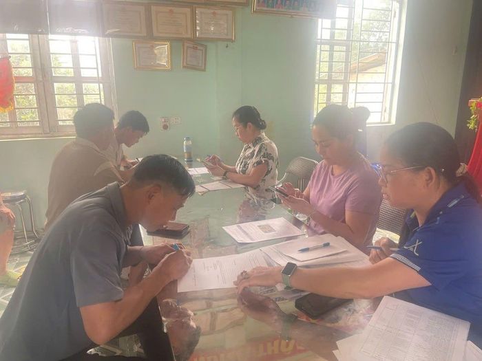 Cán bộ Quỹ hướng dẫn, hỗ trợ chủ rừng mở tài khoản để nhận tiền chi trả DVMTR tại xã Thanh Nưa. (Ảnh: QBVPTR Tỉnh Điện Biên cung cấp)